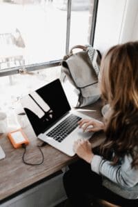 Female entrepreneur at computer, writing SEO content for her business